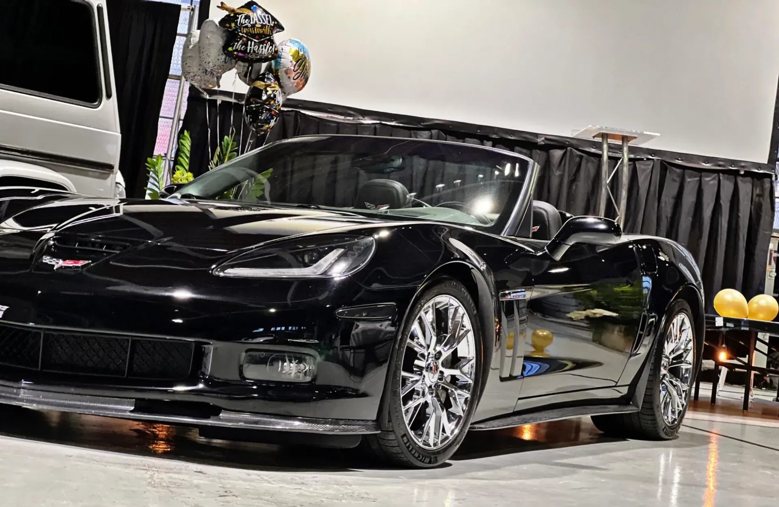 Glossy black Corvette convertible inside the studio